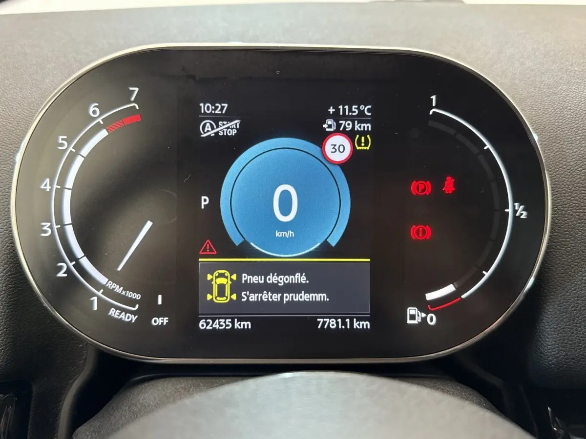 Tableau de bord numérique de MINI Countryman 2023 affichant une alerte de pneu dégonflé et la vitesse à 0 km/h.