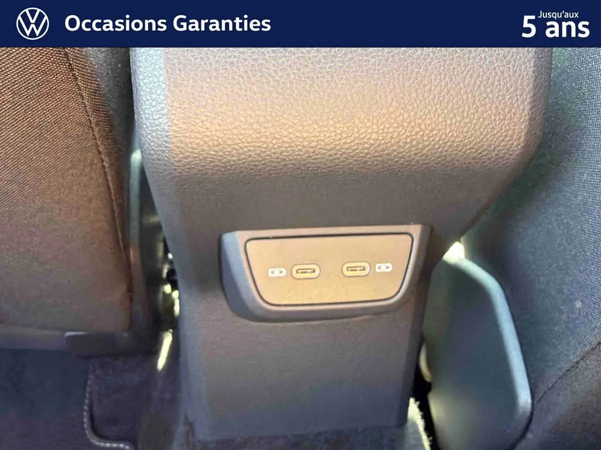 Vue rapprochée des ports USB-C arrière du Volkswagen Taigo bleu, entre les sièges avant.