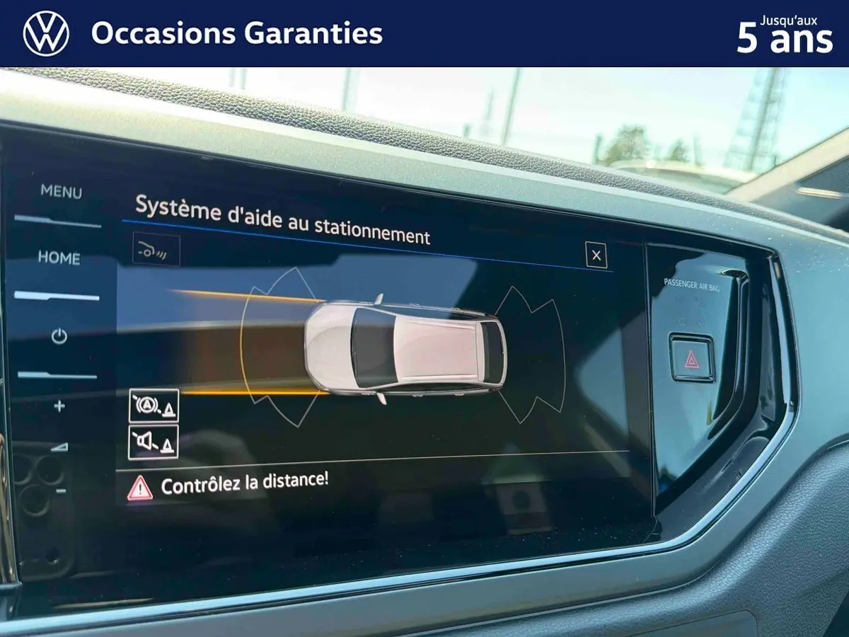 Écran tactile intérieur du Volkswagen Taigo bleu 2025 montrant le système d'aide au stationnement.