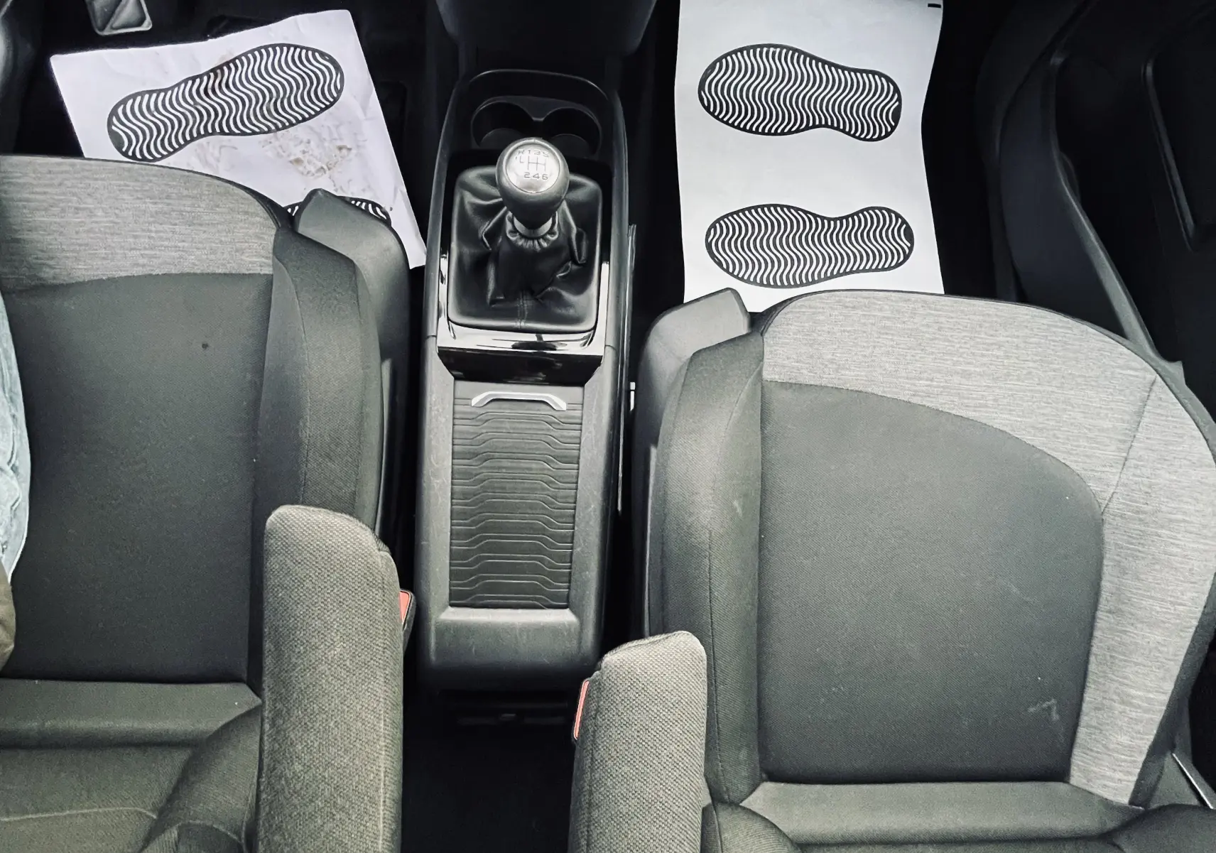 Vue plongeante sur l'intérieur avant gris et noir du Citroën C4 Picasso II avec boîte manuelle et console centrale.