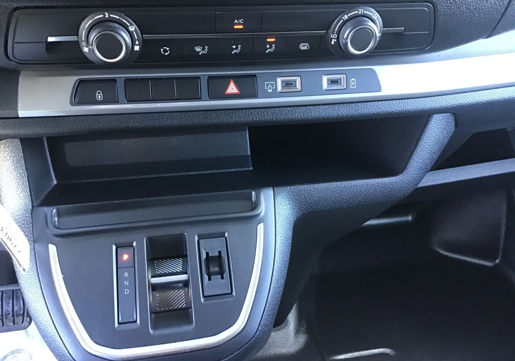 Vue rapprochée de la console centrale du Citroën Jumpy XL gris titane, montrant la commande de boîte automatique et les réglages climatisation.