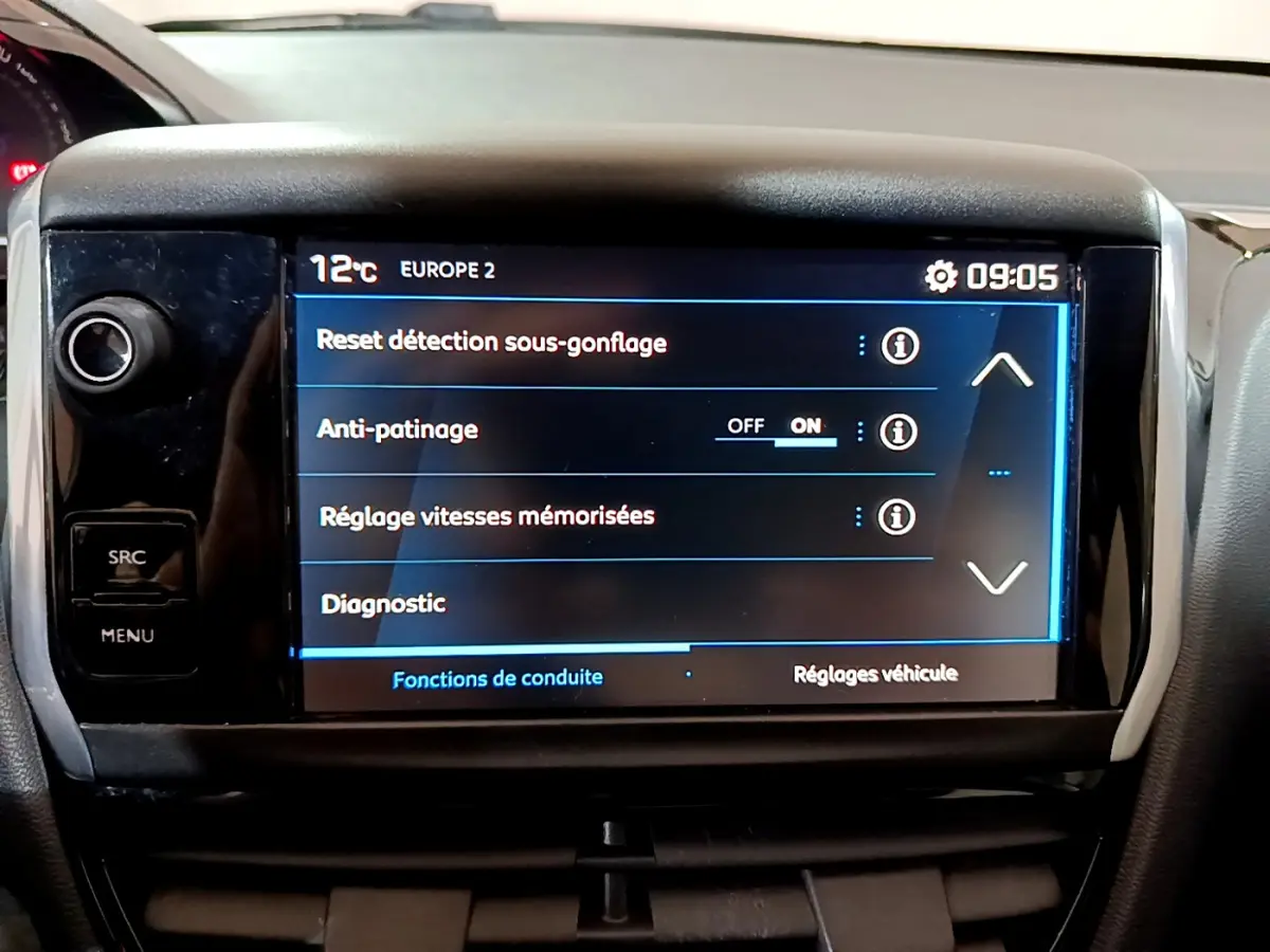 Écran tactile central affichant les réglages de conduite dans l'habitacle d'une Peugeot 208 blanche de 2018.