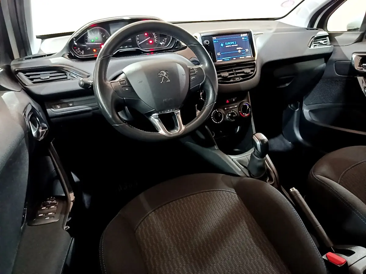 Intérieur de la Peugeot 208 Puretech 82 Signature 2018, vue côté conducteur sur volant cuir et écran tactile.