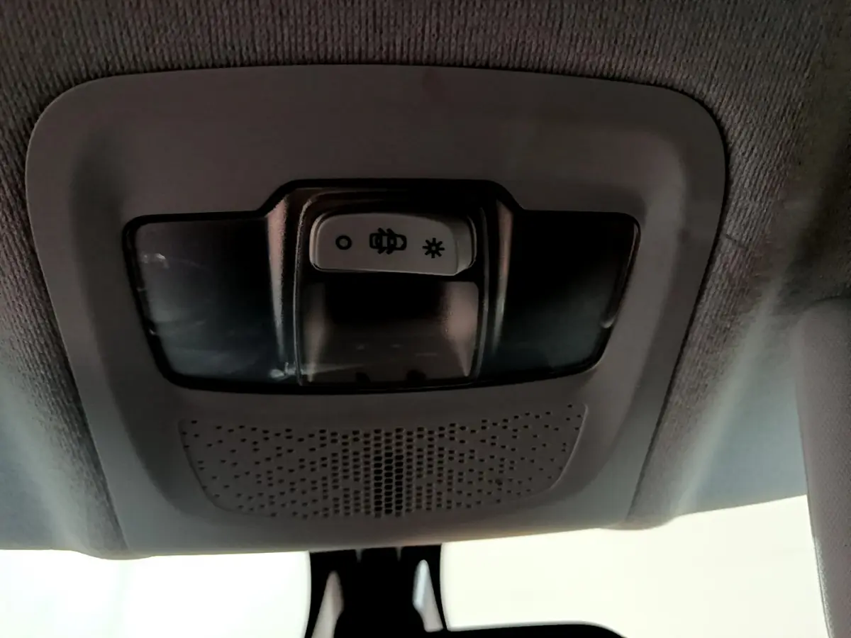 Plafonnier intérieur gris avec commandes d'éclairage, vue du toit d'une Peugeot 208 blanche Puretech 82 Signature.