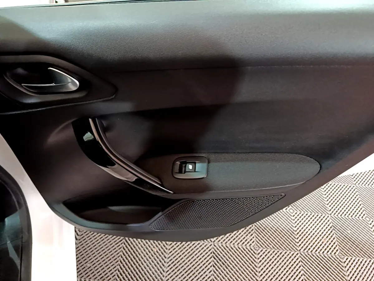 Gros plan sur la porte avant gauche noire intérieure d'une Peugeot 208 blanche Puretech 82 Signature 2018.