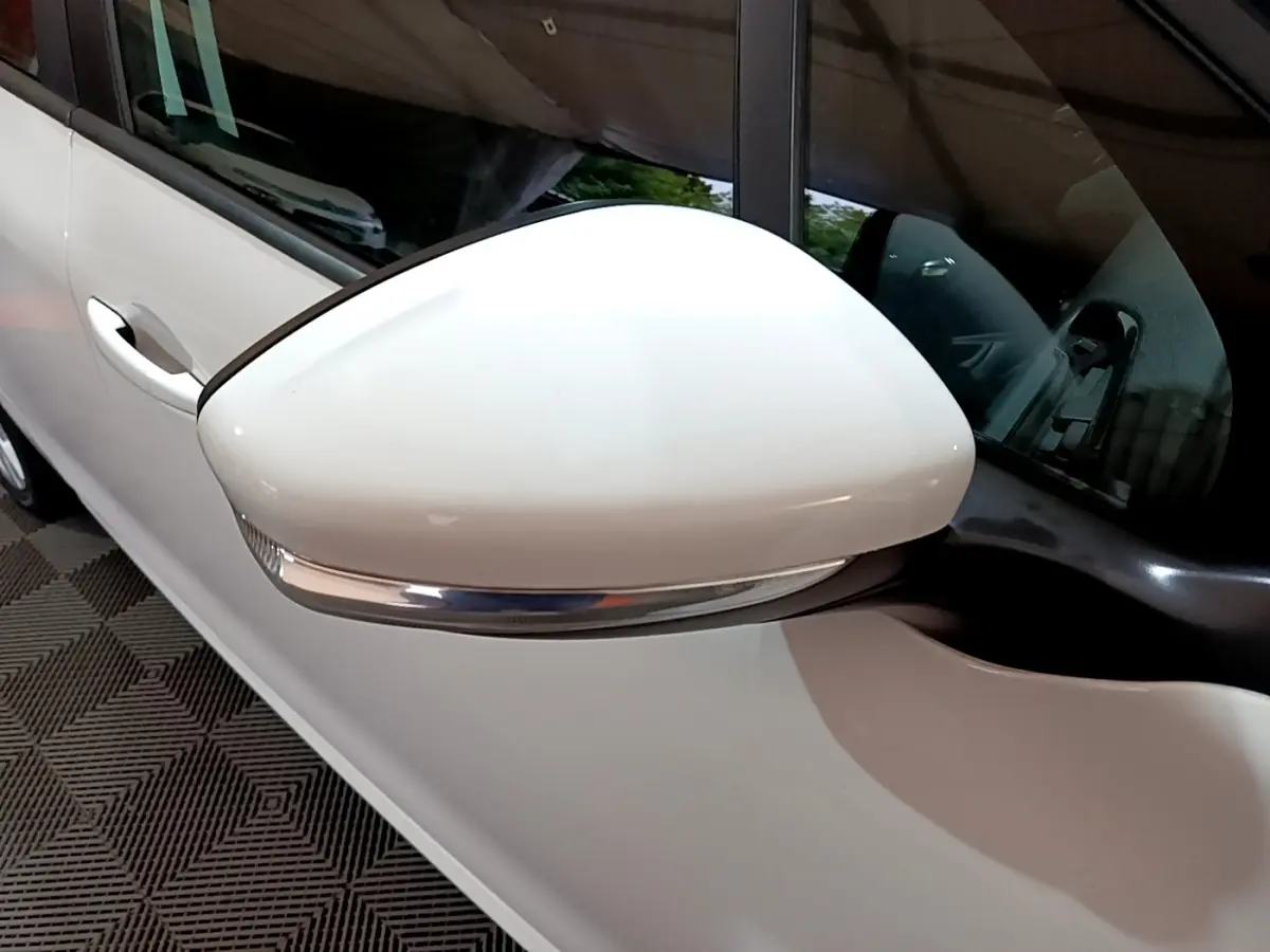 Rétroviseur droit blanc avec clignotant intégré sur une Peugeot 208 Puretech 82 Signature blanche, vue rapprochée.