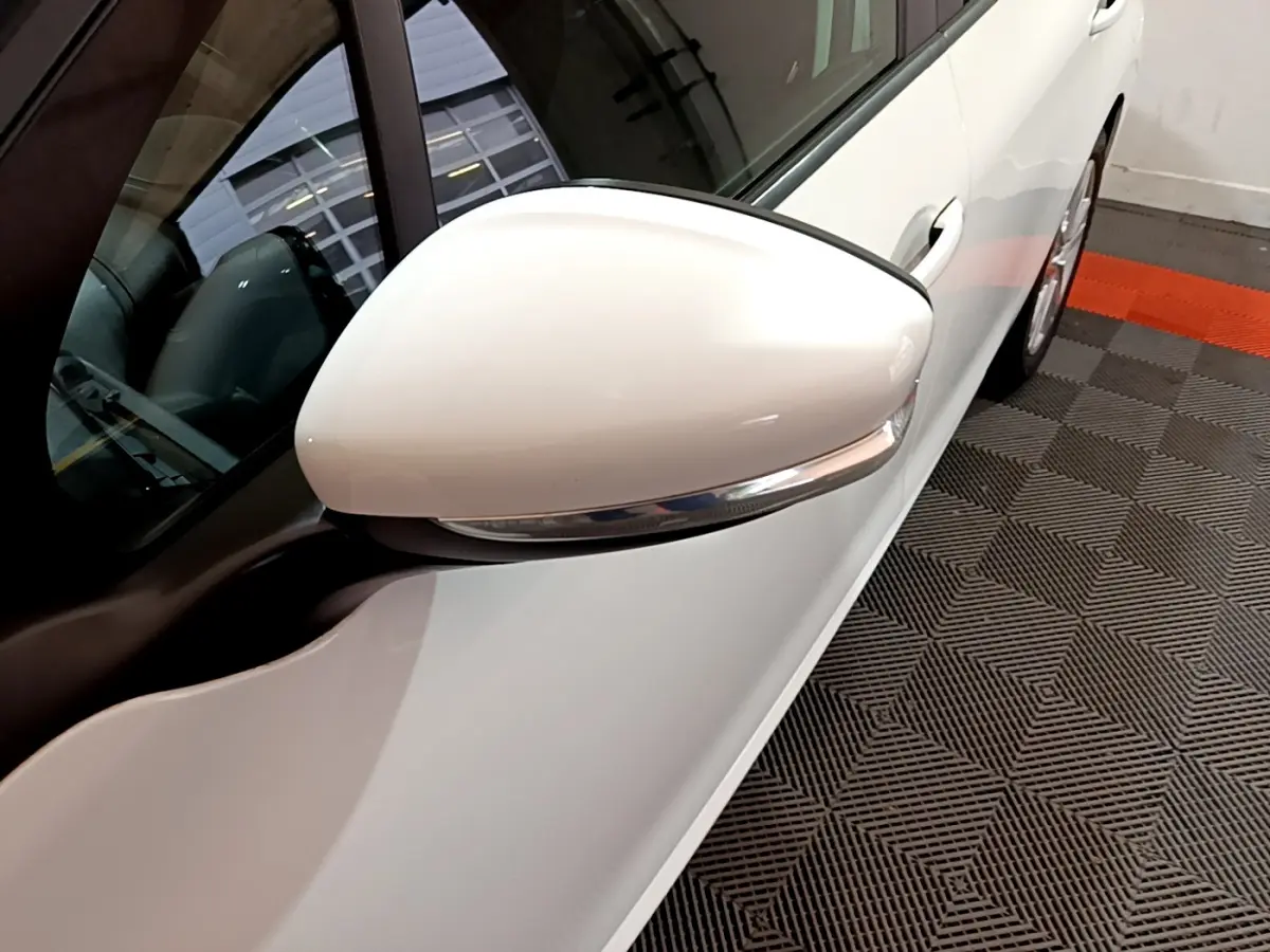 Gros plan sur le rétroviseur droit blanc d'une Peugeot 208 Puretech 82 Signature 2018, vue côté conducteur.