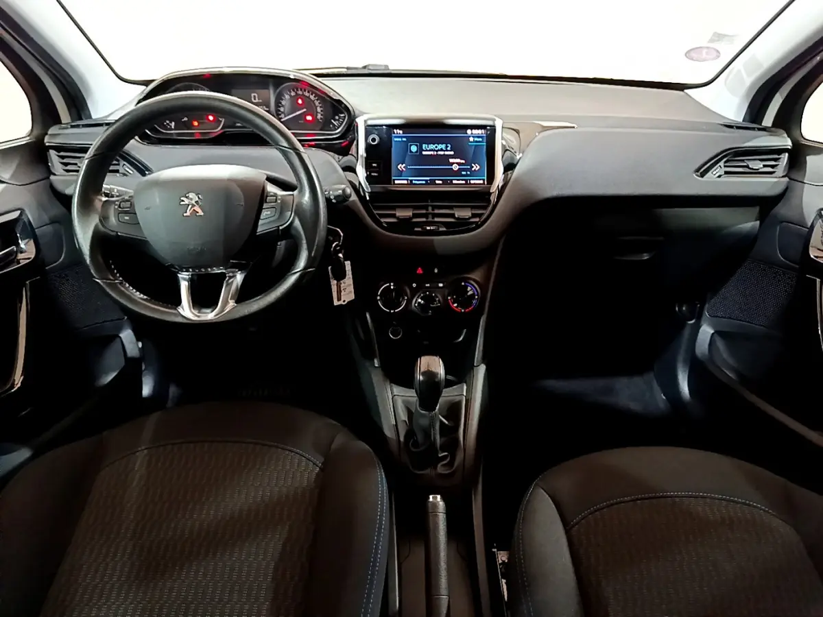 Vue intérieure frontale du tableau de bord et volant cuir noir de la Peugeot 208 Puretech 82 Signature.