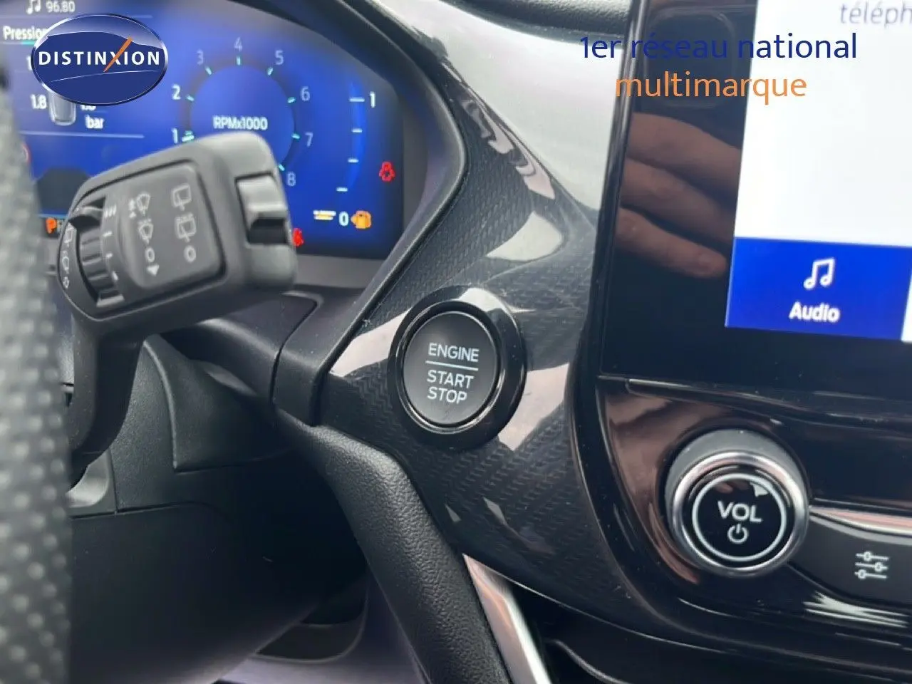 Détail intérieur du tableau de bord côté gauche du Ford Puma gris, avec bouton start/stop et écran tactile visible.