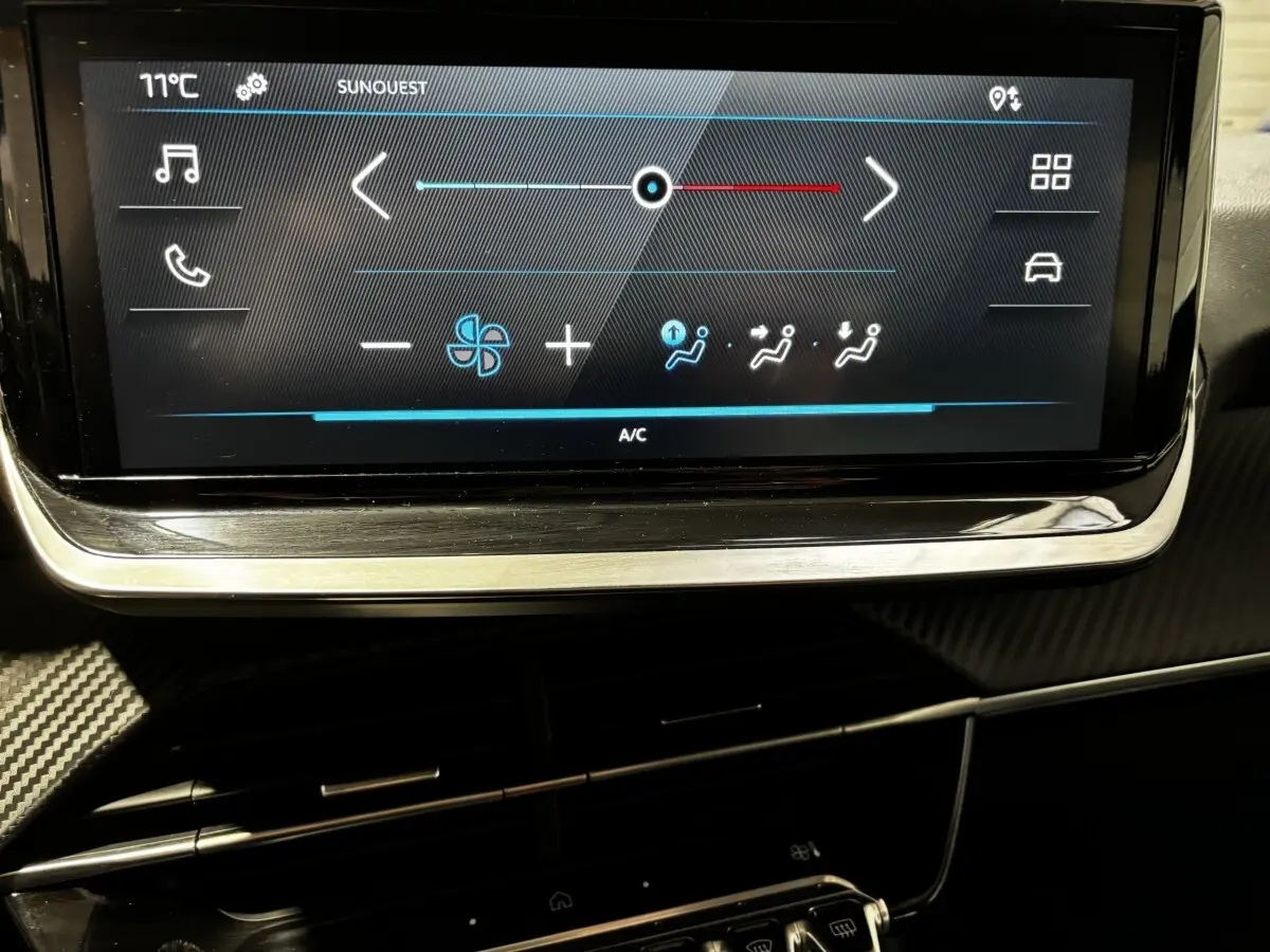 Écran tactile central affichant les commandes de climatisation du Peugeot 208 gris clair PureTech 100 S&S Active 2024