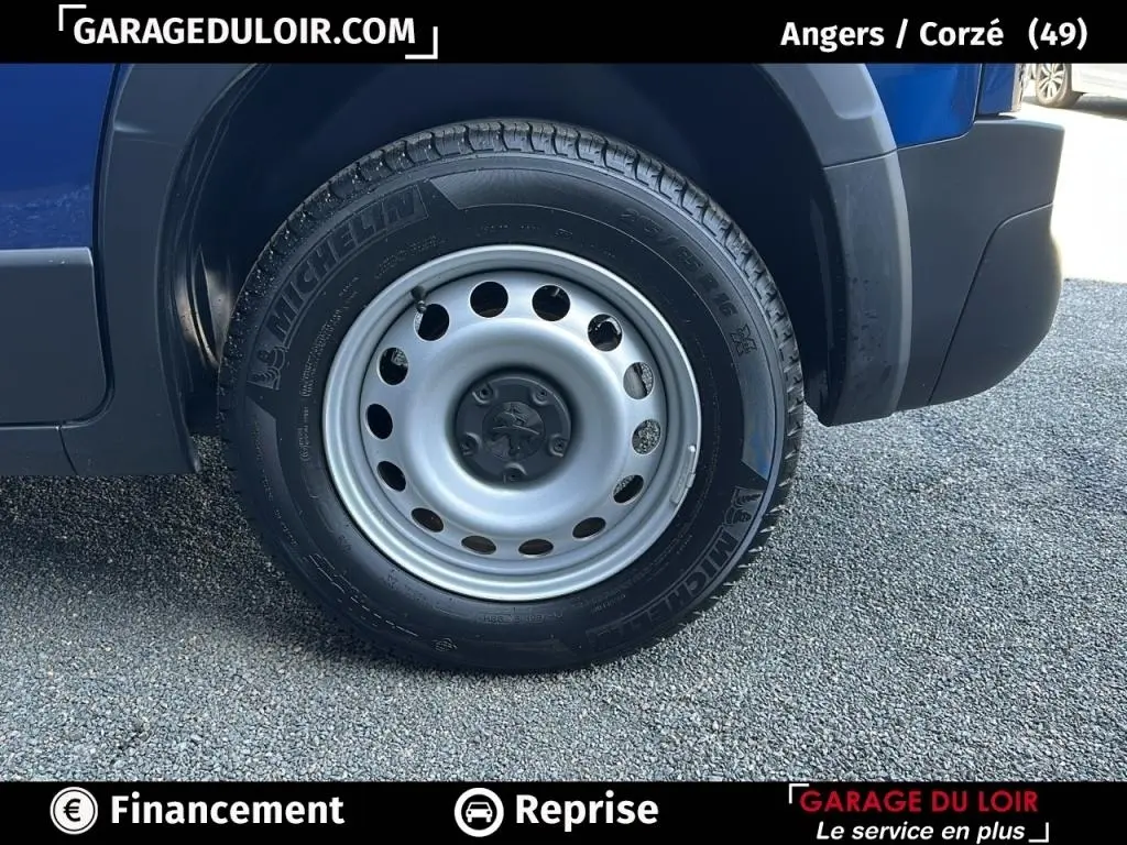 Gros plan sur la roue avant droite du Peugeot Rifter bleu 2024, mettant en valeur la jante acier et le pneu Michelin.