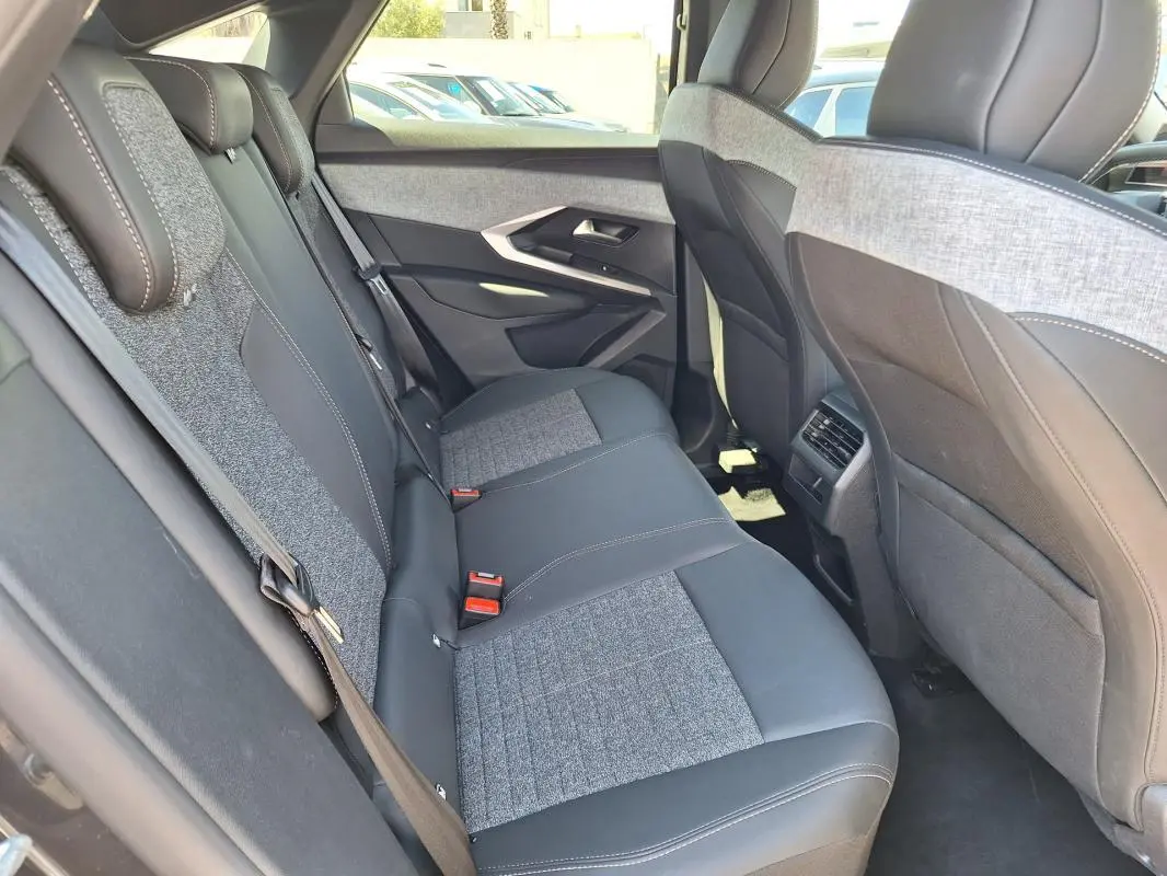 Vue intérieure côté droit des sièges arrière en tissu gris et cuir noir du Peugeot 3008 Hybrid 136 e-DCS6 Allure 2025.
