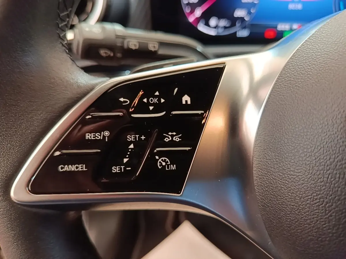 Gros plan sur les commandes du volant côté gauche d'une Mercedes Classe A 250 e Business Line noire, 2023.