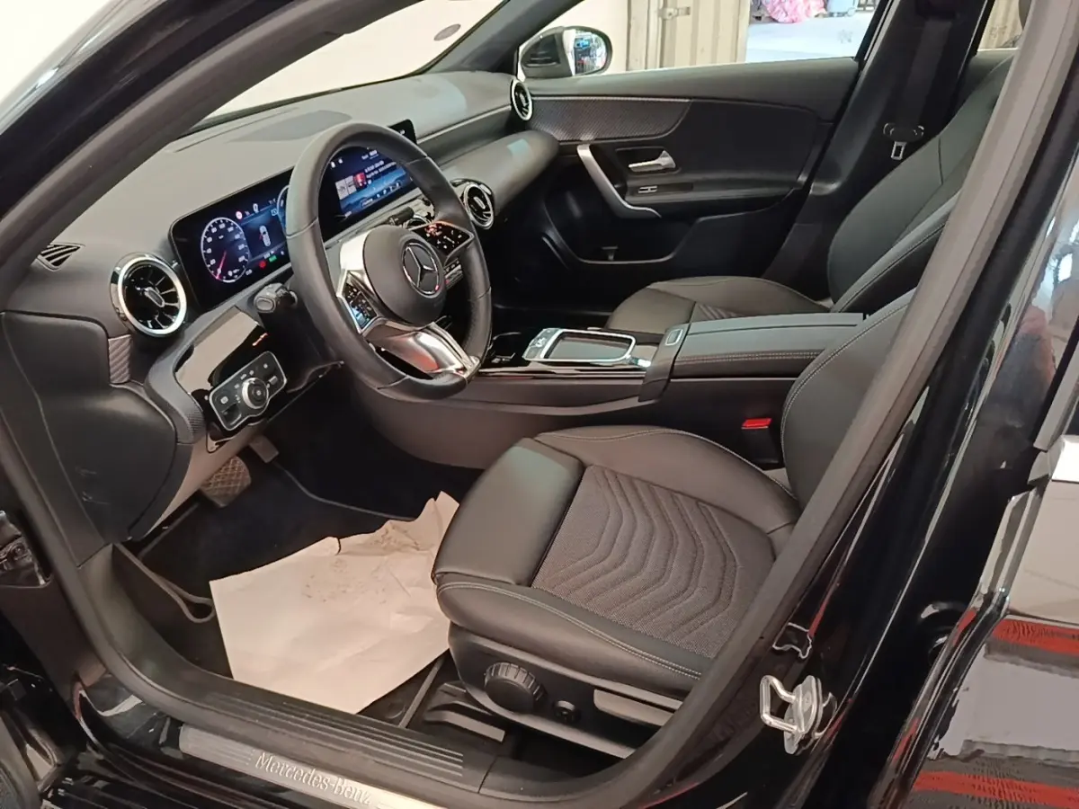 Intérieur noir de la Mercedes Classe A 250 e Business Line 2023, vue côté conducteur avec tableau de bord digital.