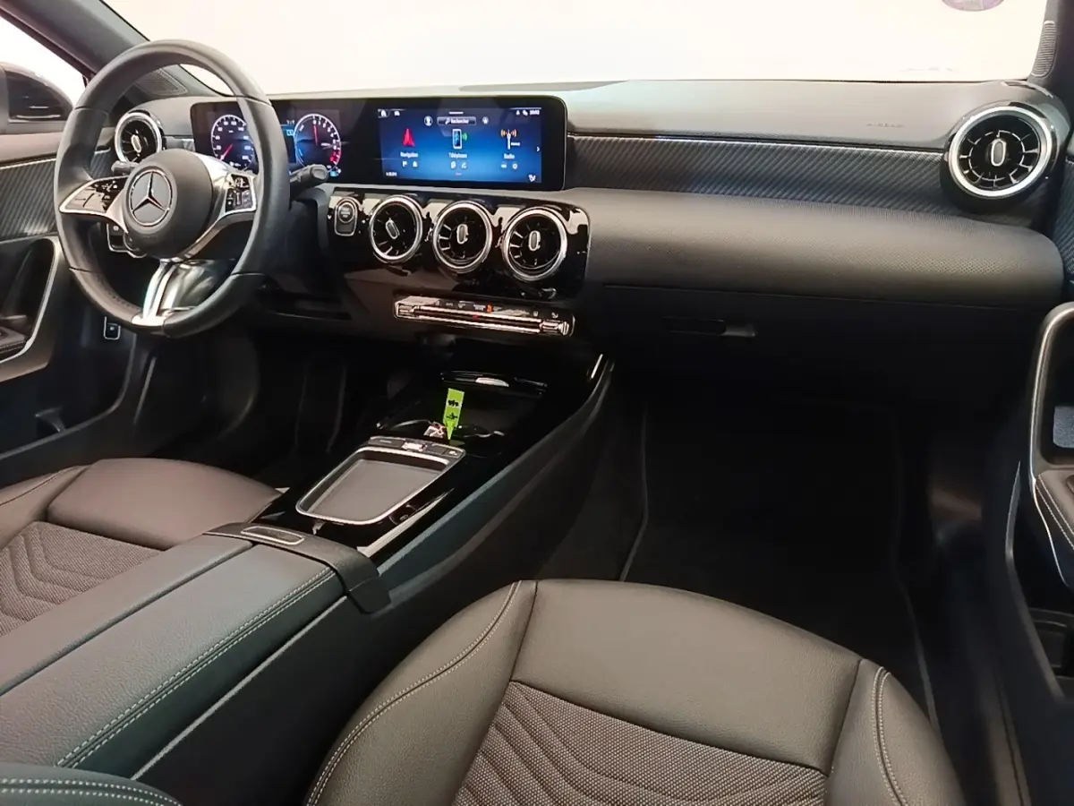 Vue intérieure avant droite de la Mercedes Classe A 250 e noire, avec tableau de bord numérique et volant cuir multifonctions.