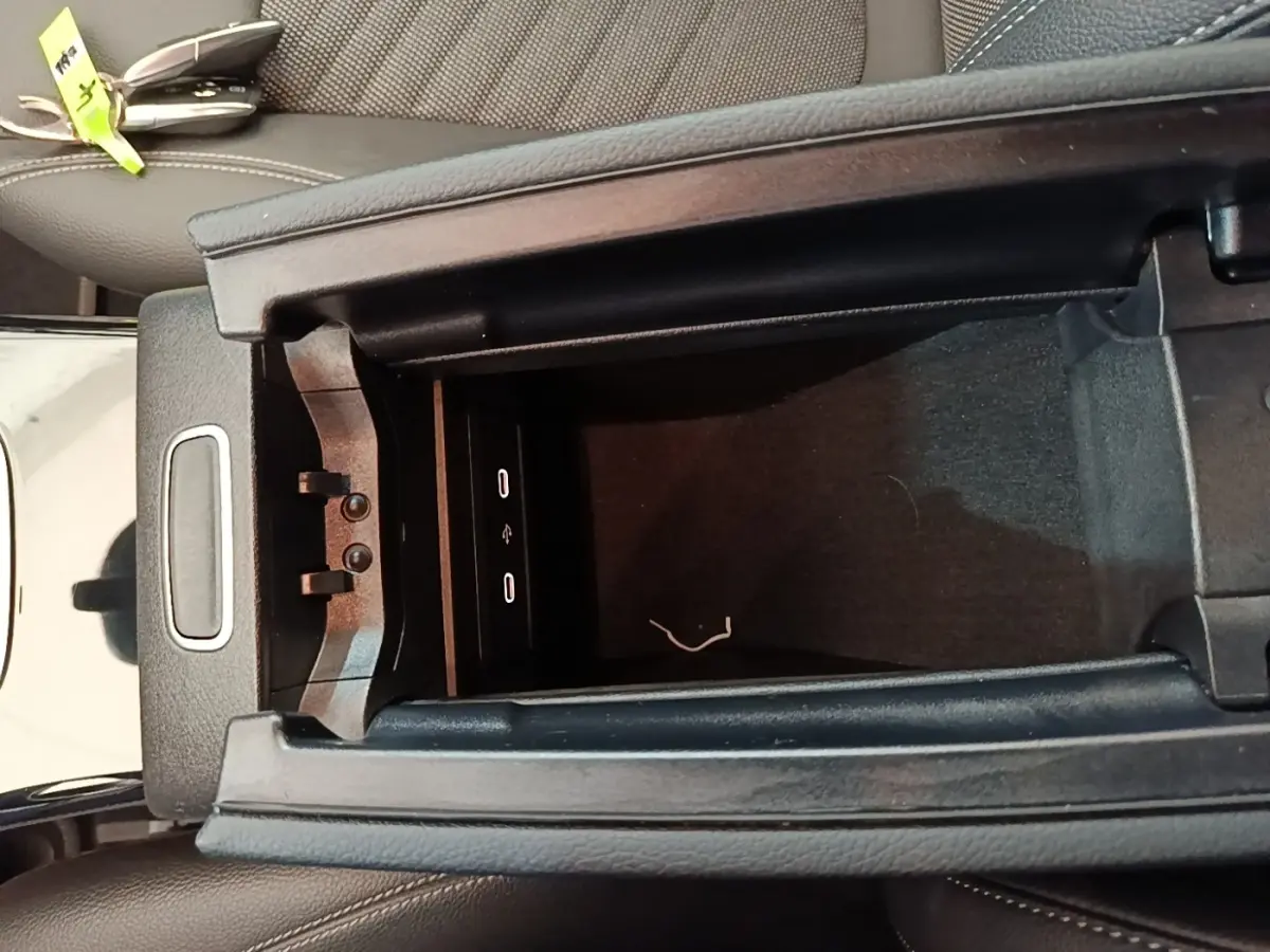 Vue rapprochée de la console centrale ouverte d’une Mercedes Classe A 250 e Business Line noire, montrant les ports USB.