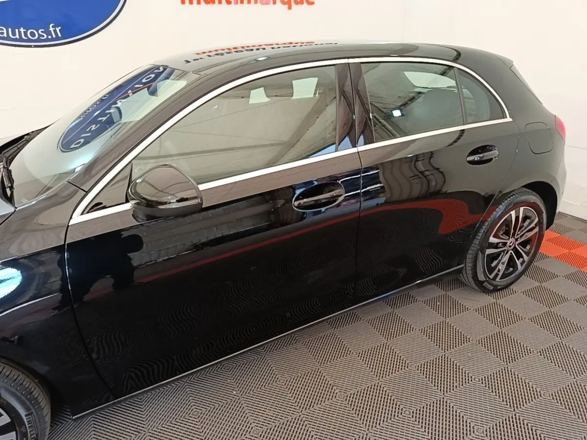 Vue de profil côté gauche d'une Mercedes Classe A 250 e Business Line noire avec jantes alliage et rétroviseurs électriques.