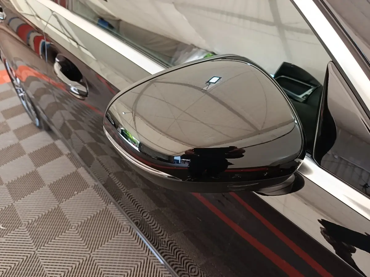 Gros plan sur le rétroviseur droit noir brillant d’une Mercedes Classe A 250 e Business Line 2023.