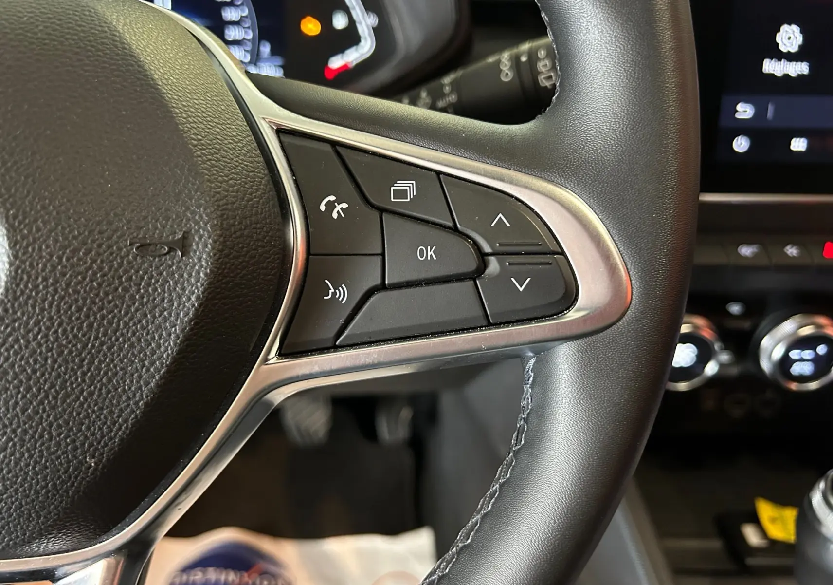 Gros plan sur les commandes au volant côté droit de la Renault Clio V 1.0 TCE 90 CH Intens, intérieur noir.