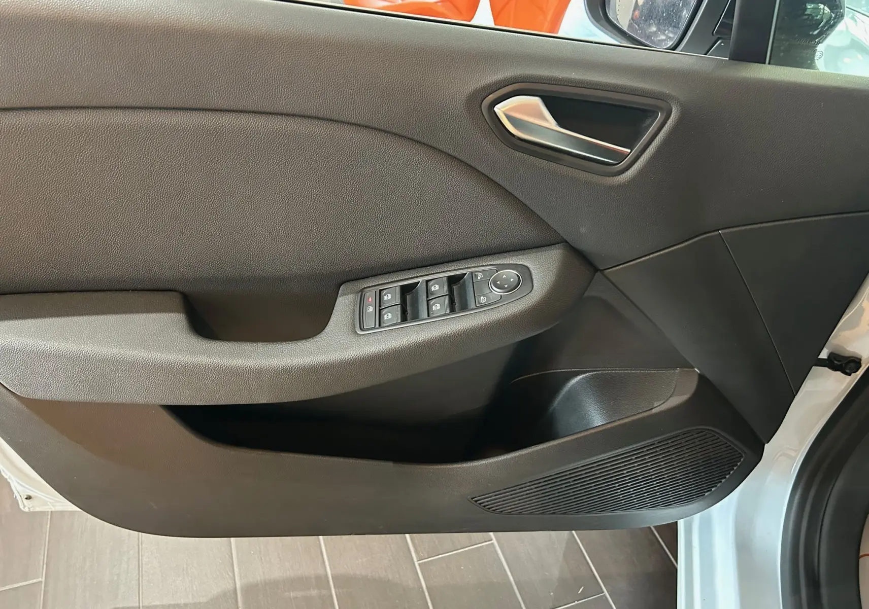 Porte avant droite ouverte de la Renault Clio V blanc nacré, avec commandes électriques des vitres et haut-parleur intégré.