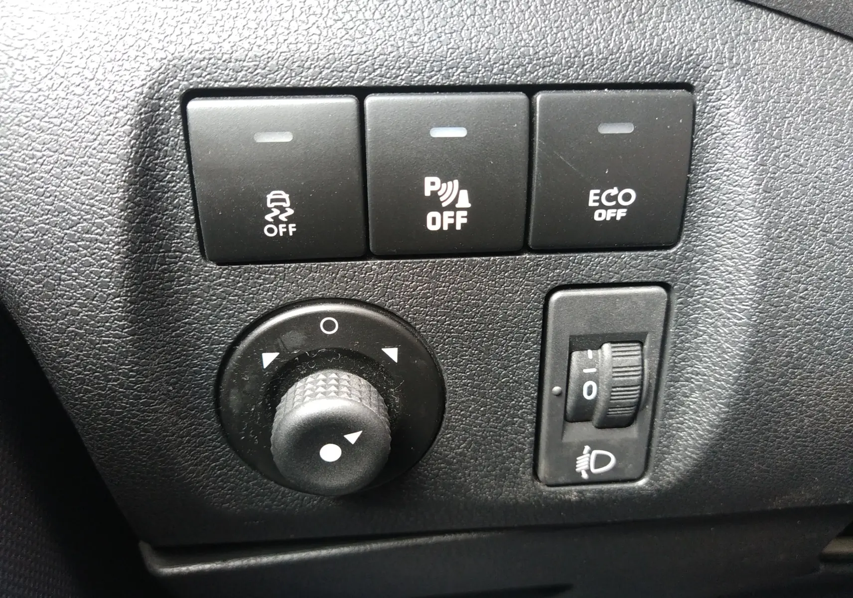 Gros plan sur les commandes de régulation de traction, stationnement et mode ECO du tableau de bord du Peugeot Partner Tepee brun 2017.