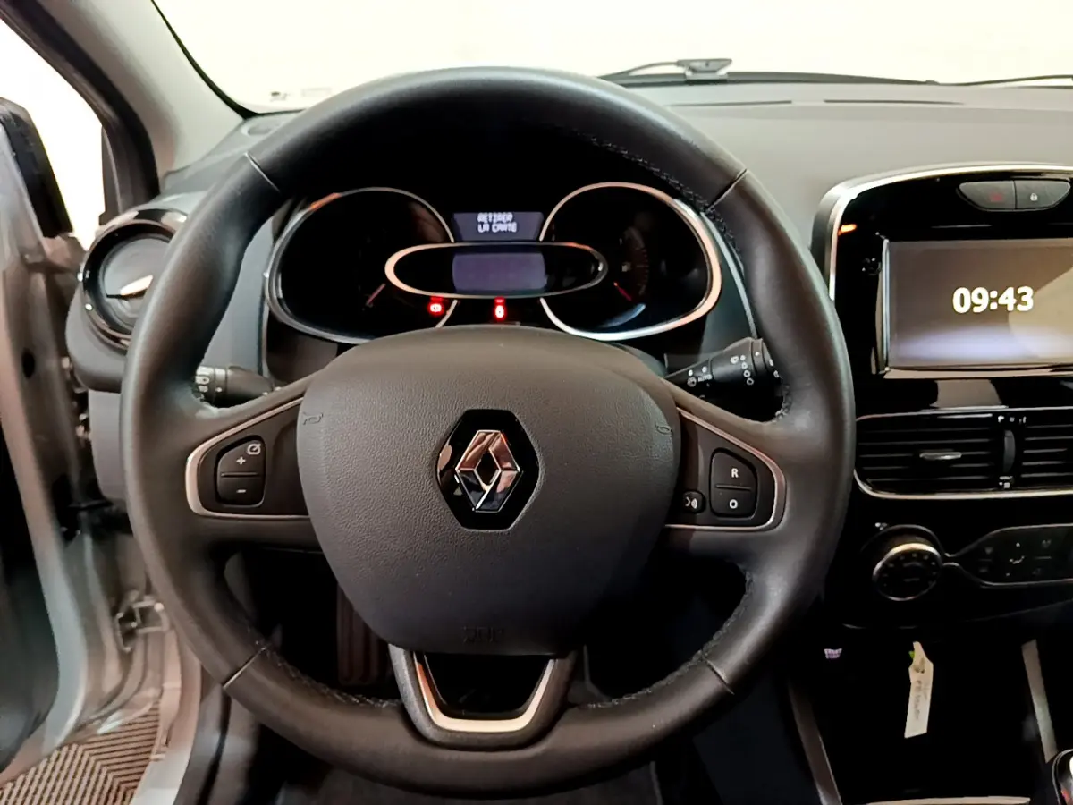 Vue intérieure centrée sur le volant cuir noir d'une Renault Clio Business TCe 90 avec tableau de bord et écran tactile.