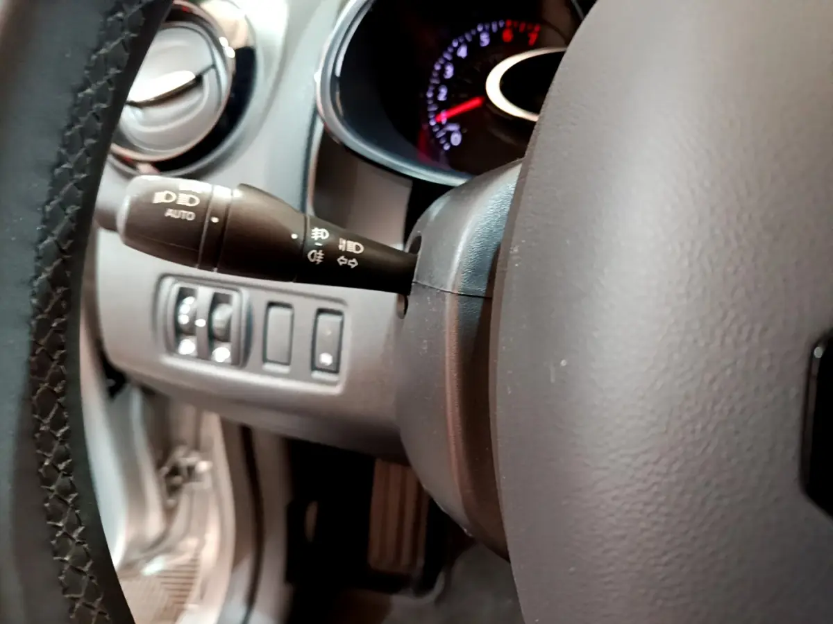 Gros plan sur la manette des phares et le volant gris foncé de la Renault Clio Business TCe 90 2019.