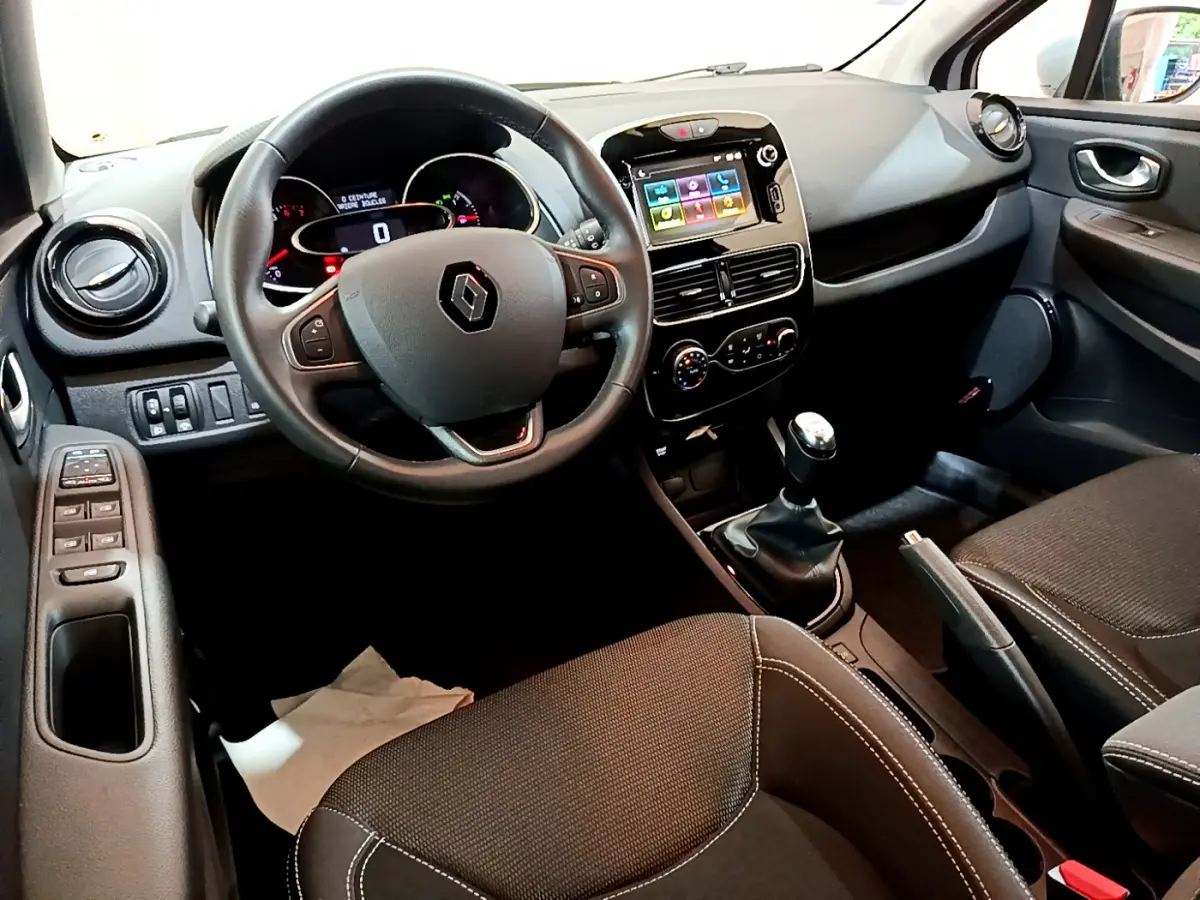 Intérieur avant droit de la Renault Clio Business TCe 90 2019, volant cuir, écran tactile et boîte manuelle visibles.