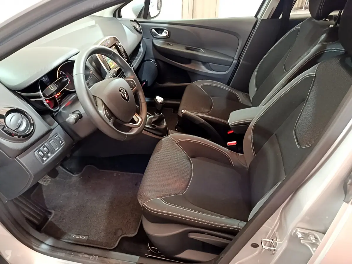 Intérieur de Renault Clio Business TCe 90 gris clair, vue côté conducteur avec volant cuir et tableau de bord tactile.