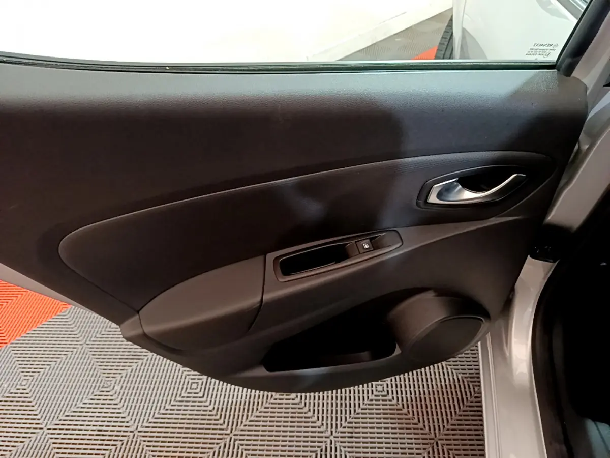 Vue rapprochée de la porte avant droite grise claire de la Renault Clio Business TCe 90 avec poignée et commande de vitre.