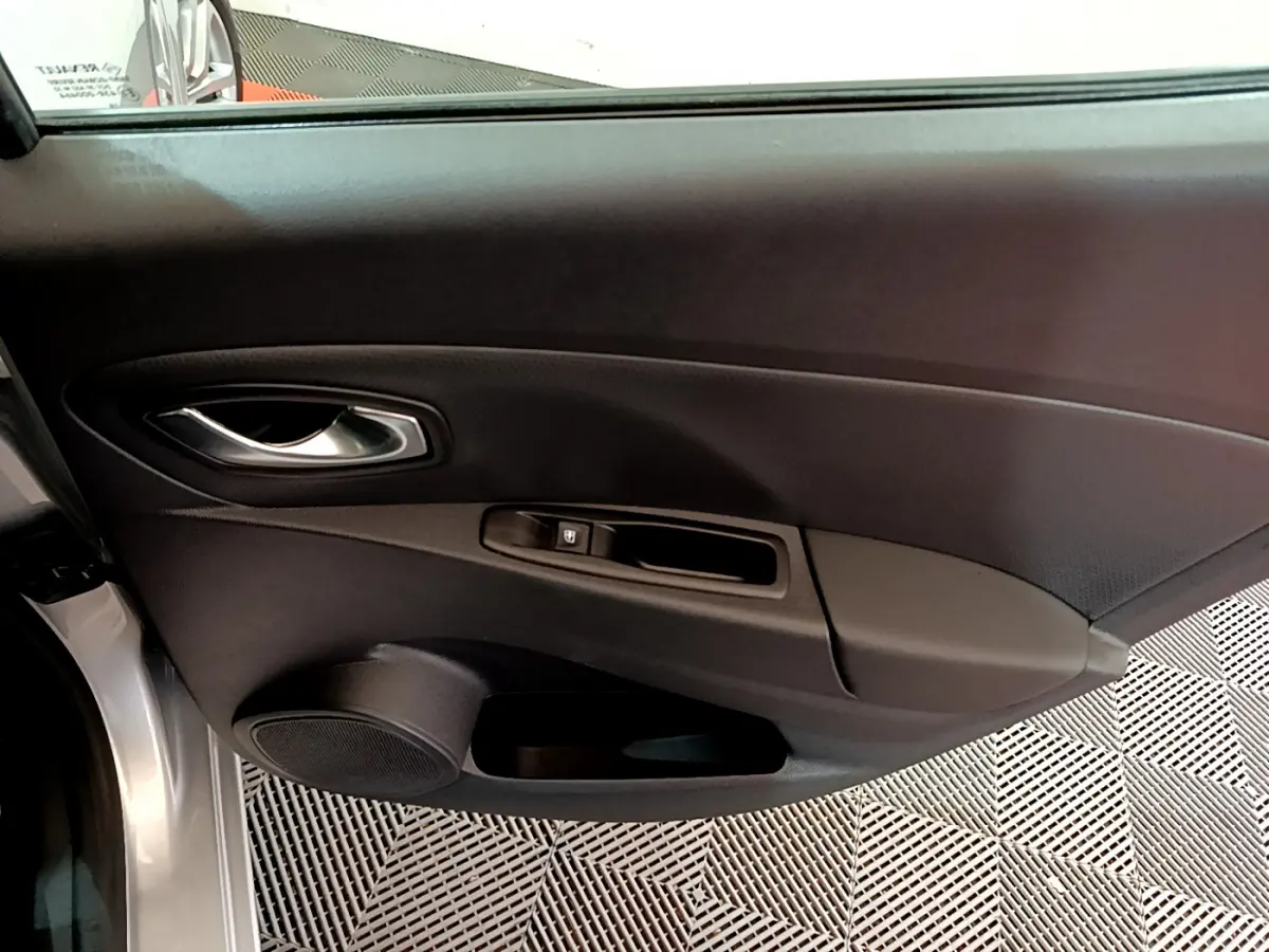 Porte côté gauche ouverte d'une Renault Clio Business TCe 90 gris clair, avec poignée intérieure et commande de vitre visible.