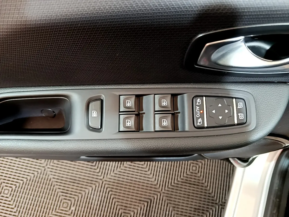 Vue rapprochée de la commande des vitres et rétroviseurs côté conducteur d'une Renault Clio Business gris clair 2019.