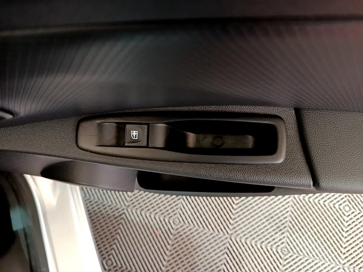Bouton de commande de lève-vitre côté conducteur sur porte intérieure d'une Renault Clio Business gris clair 2019.