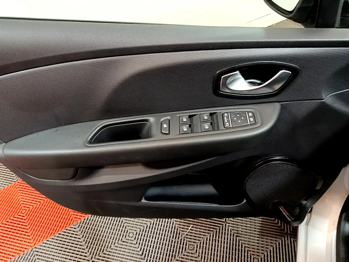 Vue rapprochée de la porte avant gauche d'une Renault Clio Business gris clair, avec commandes électriques et haut-parleur intégré.