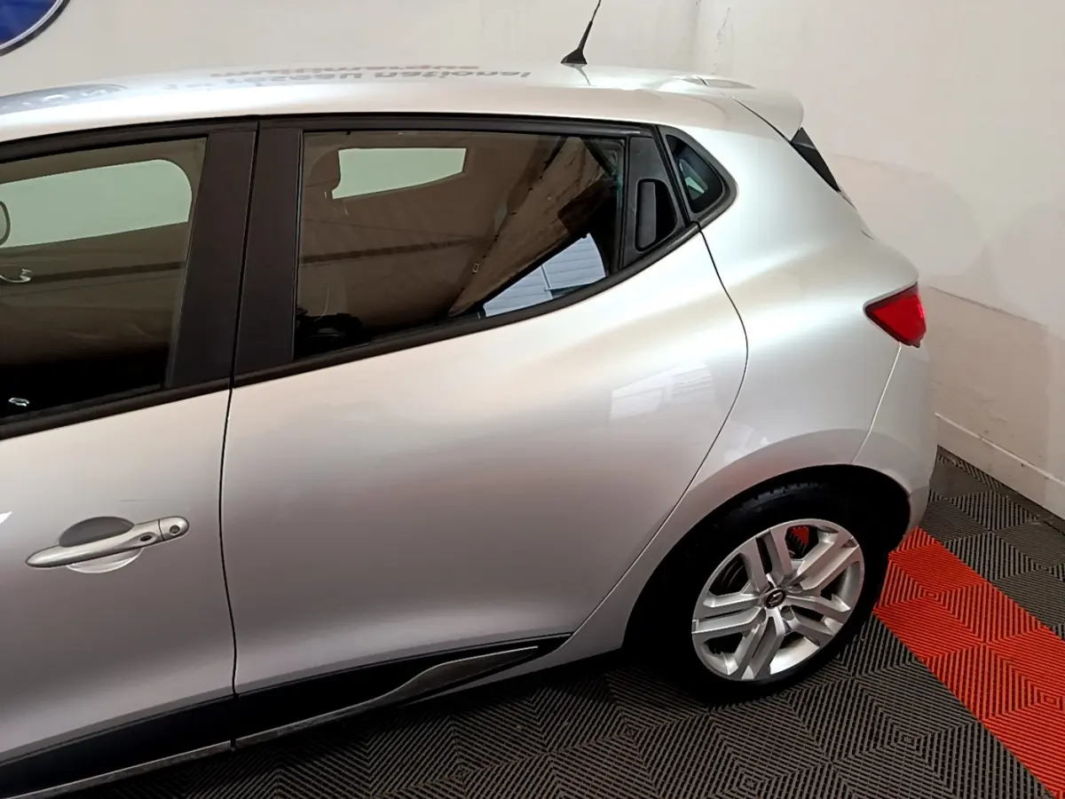Vue latérale côté gauche d'une Renault Clio Business TCe 90 gris clair, avec jante alliage et poignée de porte visible.
