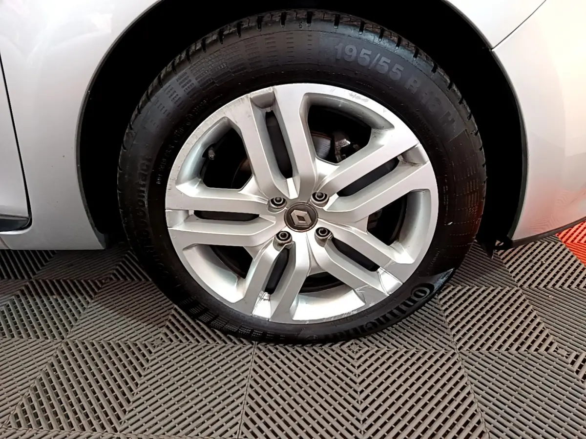 Gros plan sur la roue avant gauche gris clair d'une Renault Clio Business TCe 90 avec jante alliage cinq branches.