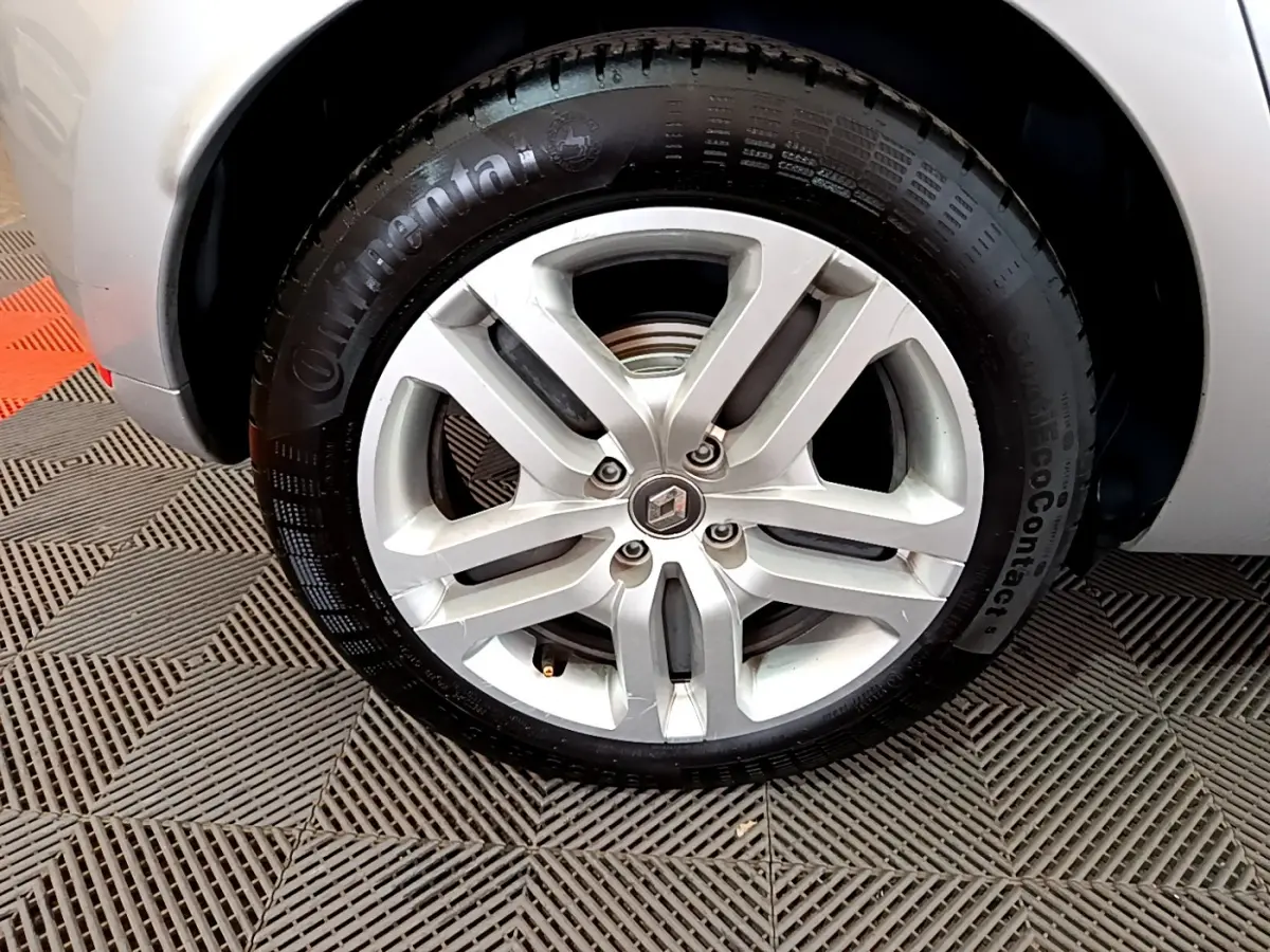 Gros plan sur la roue avant droite gris clair d'une Renault Clio Business TCe 90 avec jante alliage et logo Renault au centre.