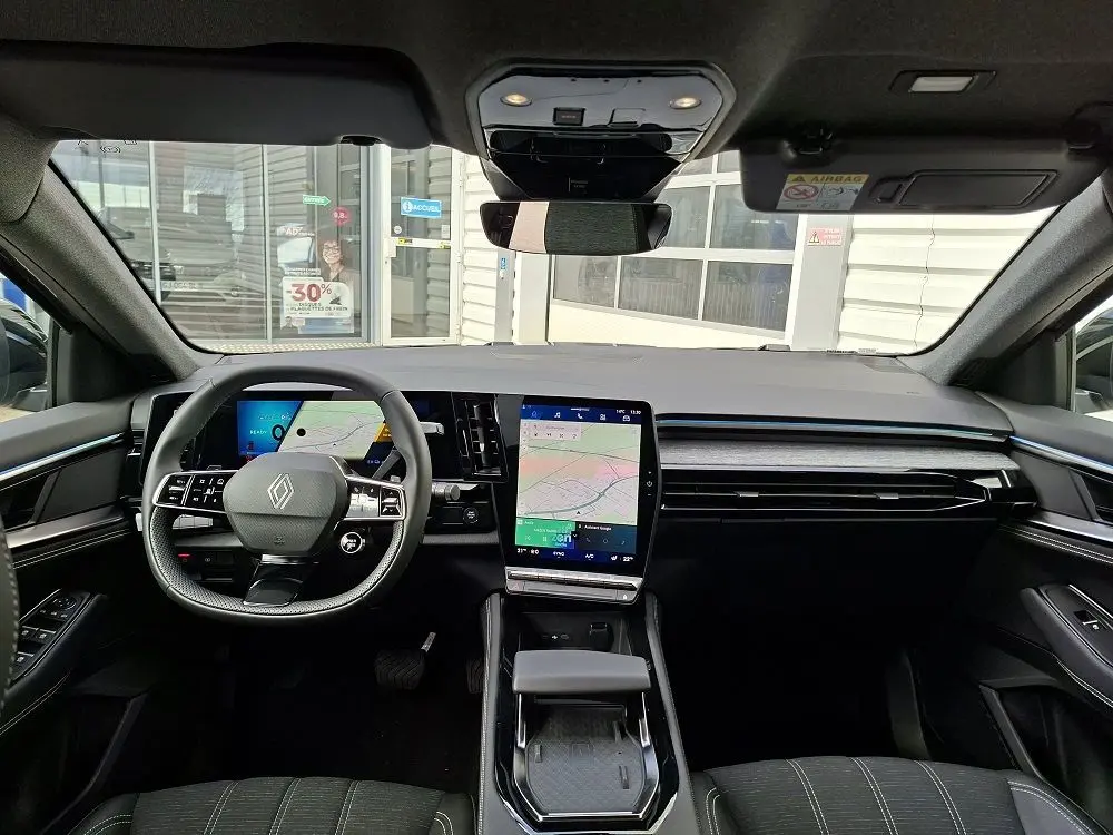 Vue intérieure avant du Renault Austral E-Tech Full Hybrid 2025, tableau de bord moderne avec écran tactile vertical et volant multifonction.