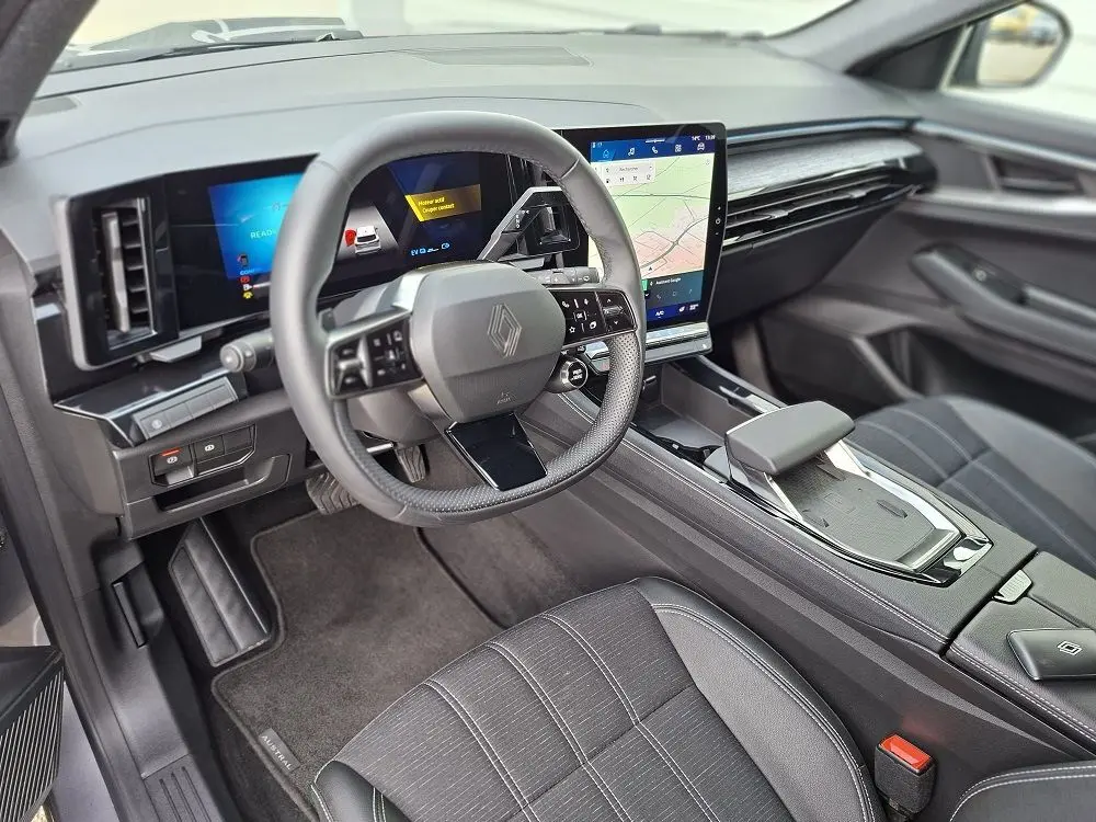 Vue intérieure côté conducteur du Renault Austral E-Tech Full Hybrid 2025, avec tableau de bord numérique et écran tactile vertical.