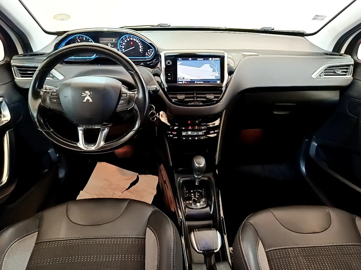 Vue intérieure avant du Peugeot 2008 2019 avec tableau de bord noir, écran tactile de navigation et volant cuir multifonctions.