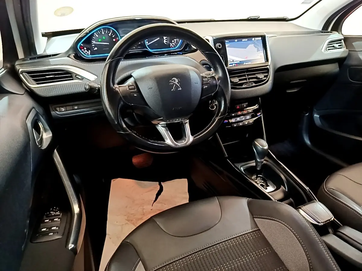 Vue intérieure du poste de conduite du Peugeot 2008 2019 avec volant cuir noir et écran tactile central allumé.
