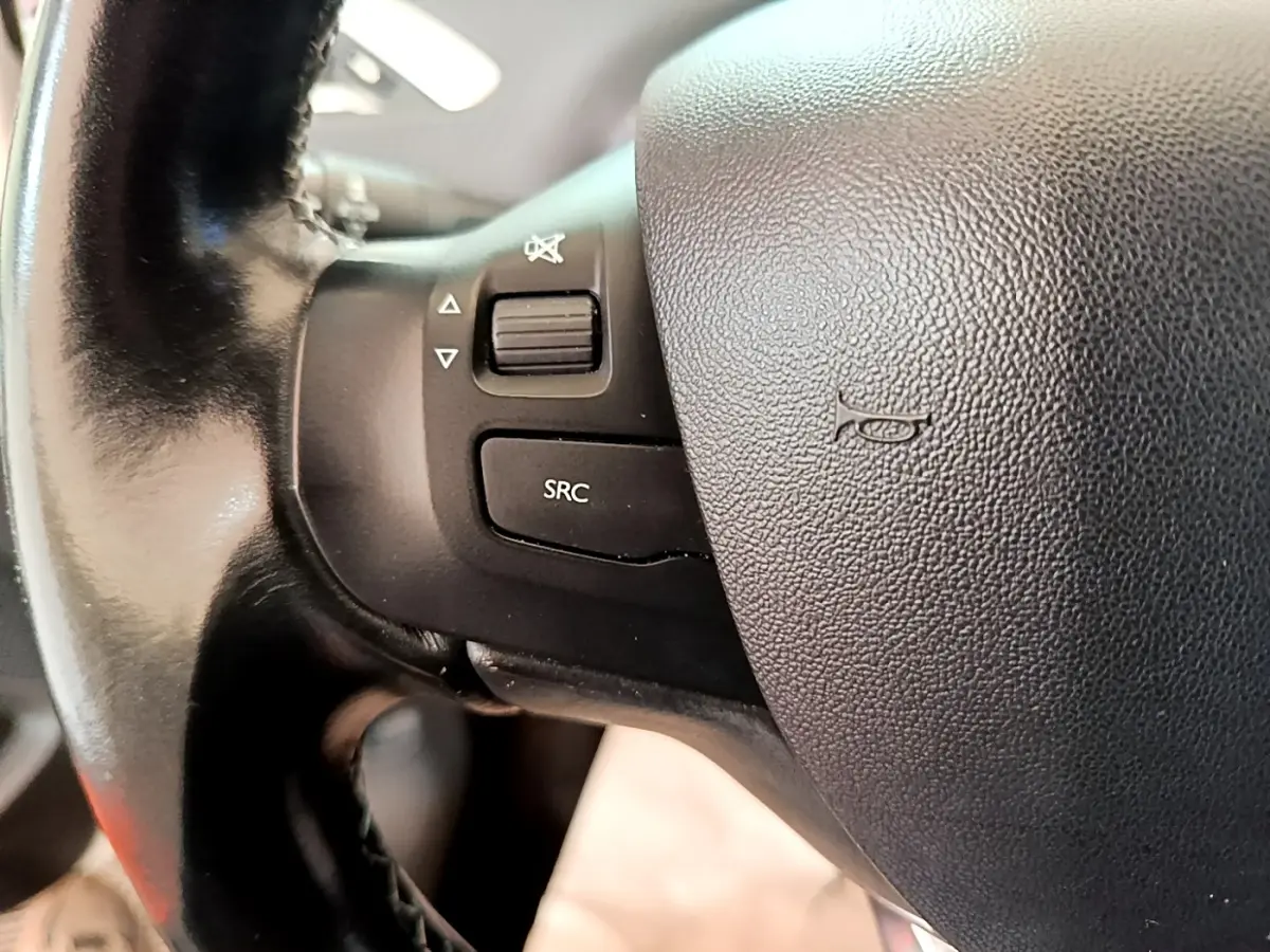 Gros plan sur le volant cuir noir de la Peugeot 2008 2019 avec commandes audio intégrées côté gauche.