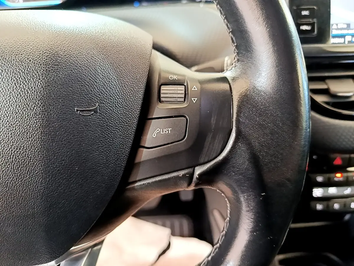 Gros plan sur le volant cuir noir de la Peugeot 2008 2019 avec commandes multifonctions et tableau de bord partiel visible.