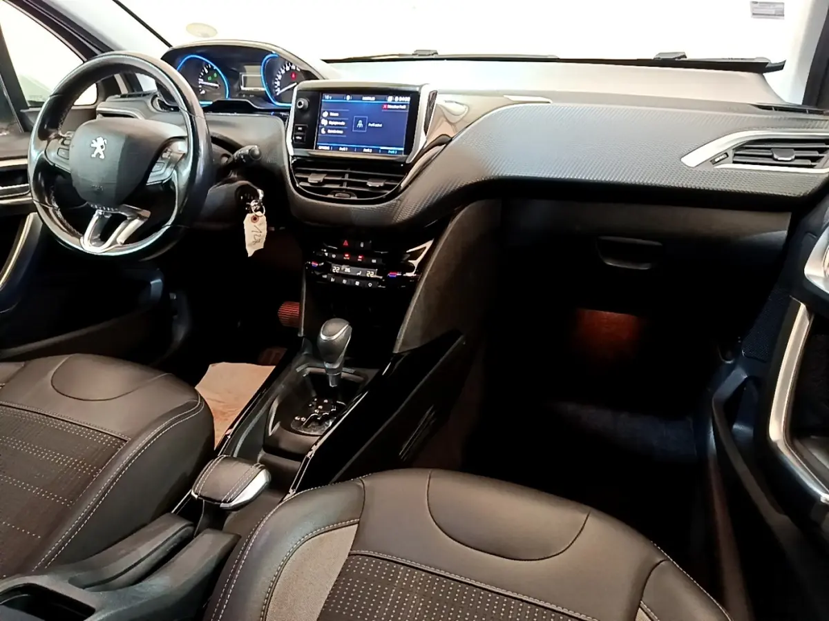 Vue intérieure avant droite du Peugeot 2008 2019, tableau de bord noir avec écran tactile et volant cuir multifonctions.