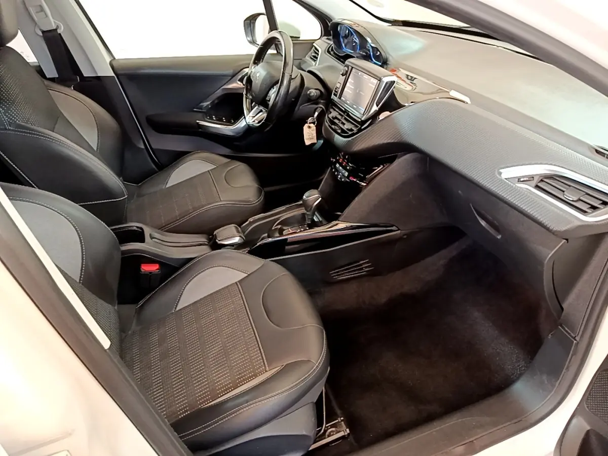 Intérieur avant droit du Peugeot 2008 2019, sièges noirs, tableau de bord avec écran tactile et volant cuir.