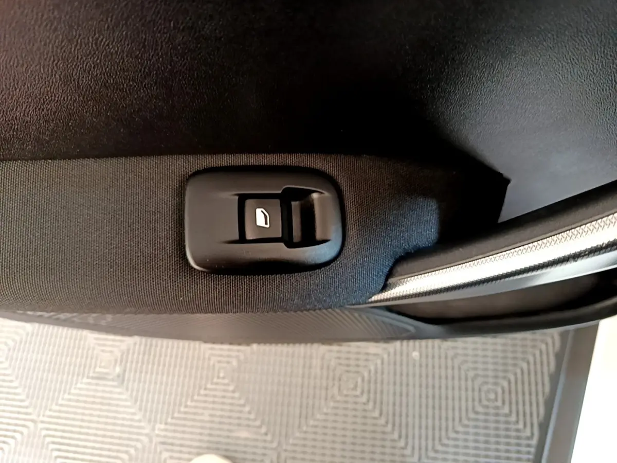Gros plan sur le bouton de verrouillage de porte côté intérieur d'une Peugeot 2008 2019, tissu noir et garniture argentée.