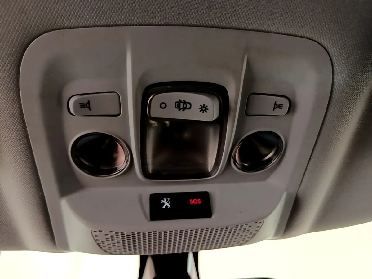 Vue en gros plan du plafonnier intérieur gris du Peugeot 2008 avec boutons d’éclairage et alerte SOS rouge allumée.