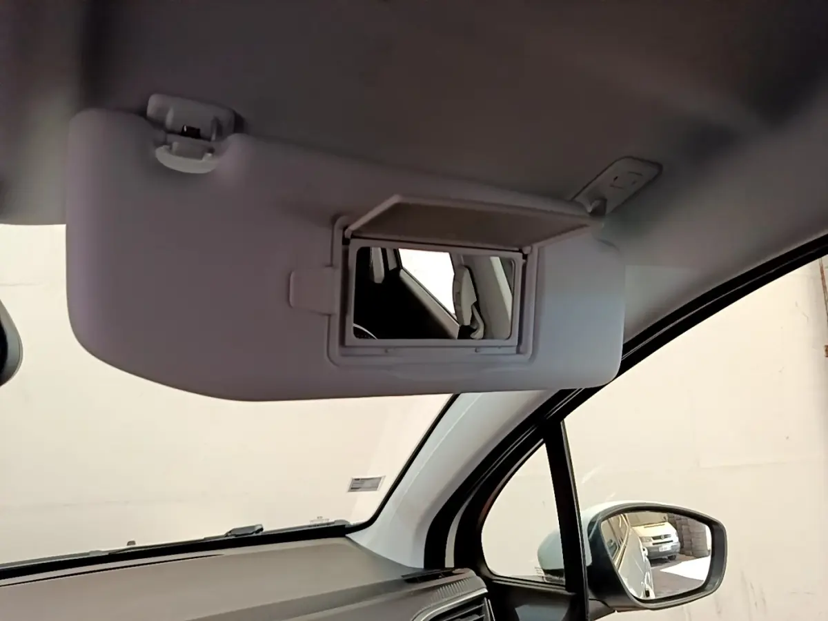 Miroir de courtoisie ouvert sur pare-soleil côté conducteur dans l’habitacle clair d’un Peugeot 2008 2019.