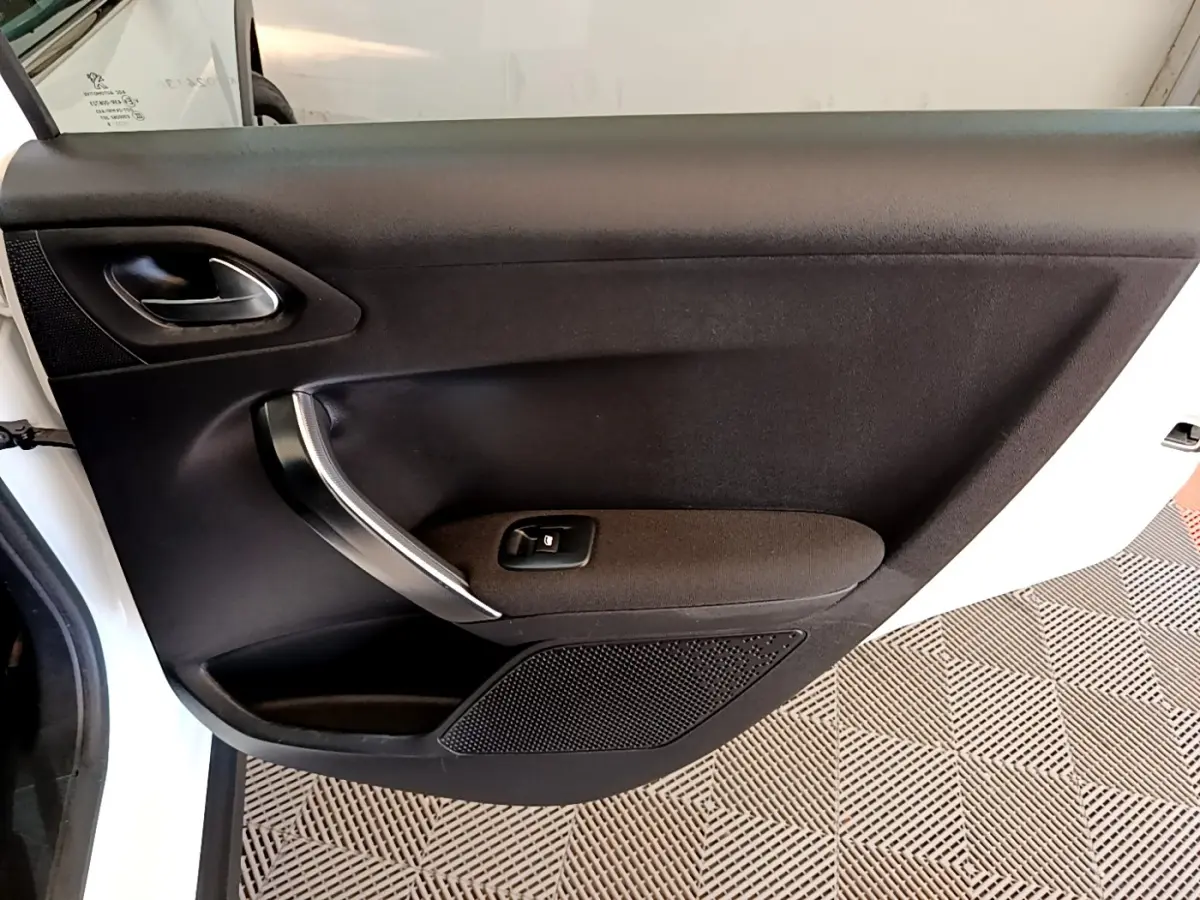 Vue intérieure de la porte arrière gauche noire du Peugeot 2008, avec poignée argentée et bouton de lève-vitre.