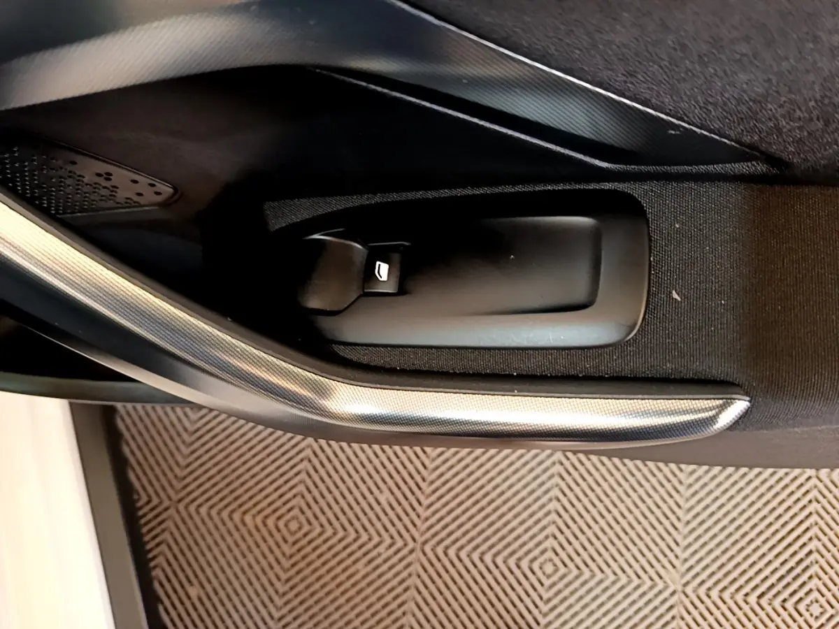 Détail de la poignée intérieure de porte côté conducteur du Peugeot 2008 2019 avec insert décoratif gris.
